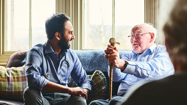 Smiling doctor visiting senior man at home