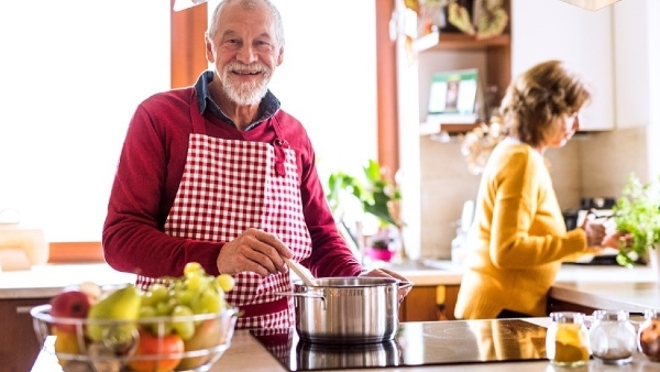 Elderly couple in kitchen cooking